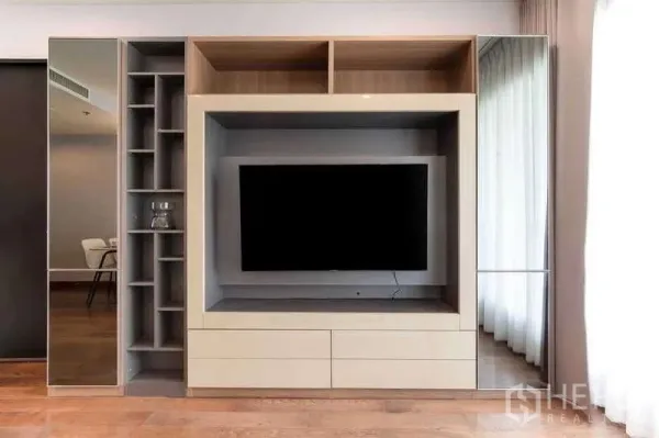 Condominium for rent in Pathum Wan, Bangkok - Close-up of modern built-in TV cabinet with shelving and mirrored side panels.