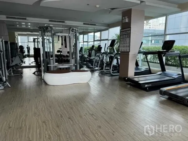 公寓 出售在Ratchathewi, Bangkok - 健身房配跑步机、力量训练器械与落地窗。