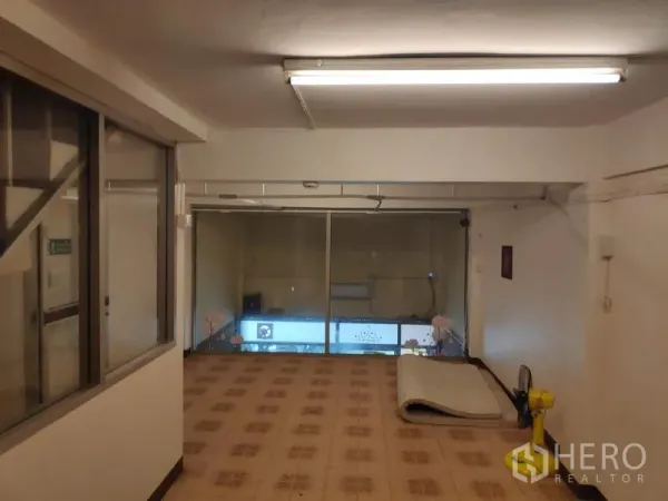 联排别墅 出租在Sathon, Bangkok - 楼上房间，花纹地砖与整面前窗，可俯瞰街景。