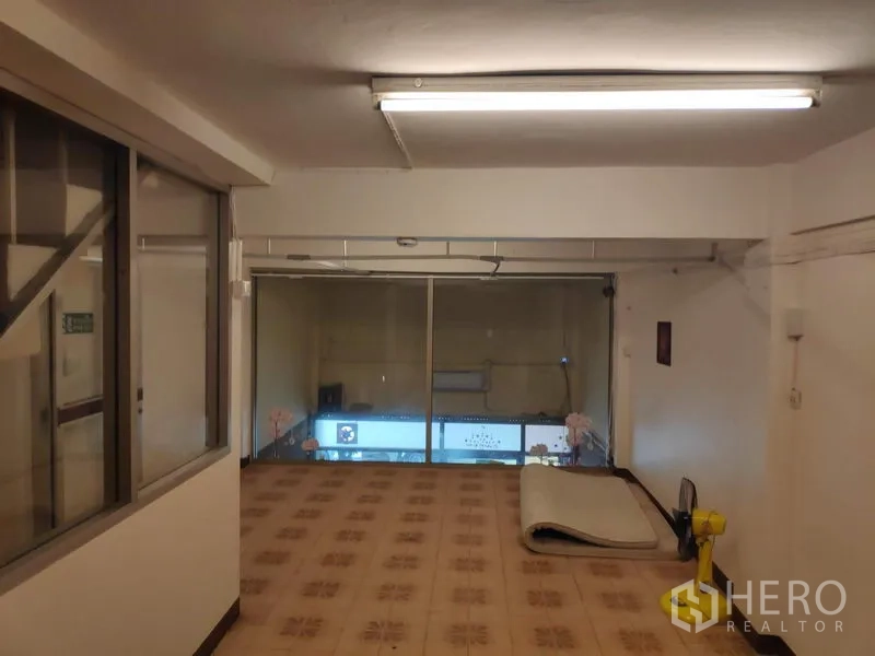 联排别墅 出租在Sathon, Bangkok - 楼上房间，花纹地砖与整面前窗，可俯瞰街景。