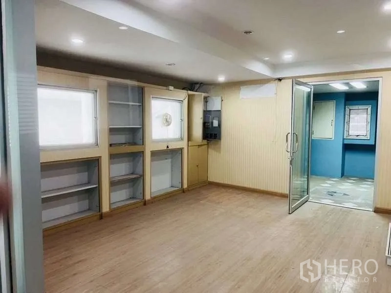 带办公室的家 出售在Huai Khwang, Bangkok - 带内置书架的工作室，木地板与通往相邻空间的玻璃门