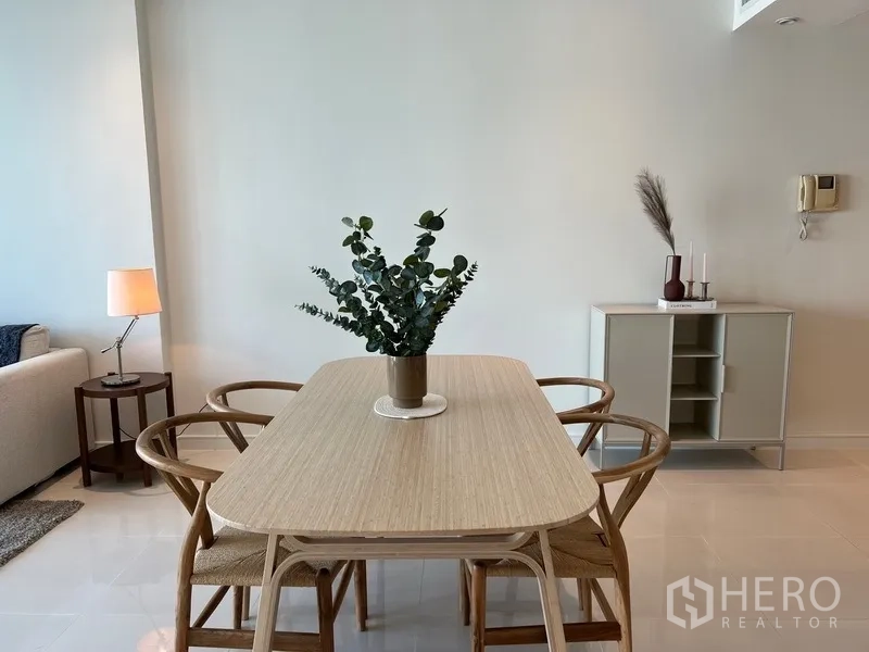 公寓 出租在Watthana, Bangkok - 简约六人餐桌，绿植点缀，墙面清爽干净。