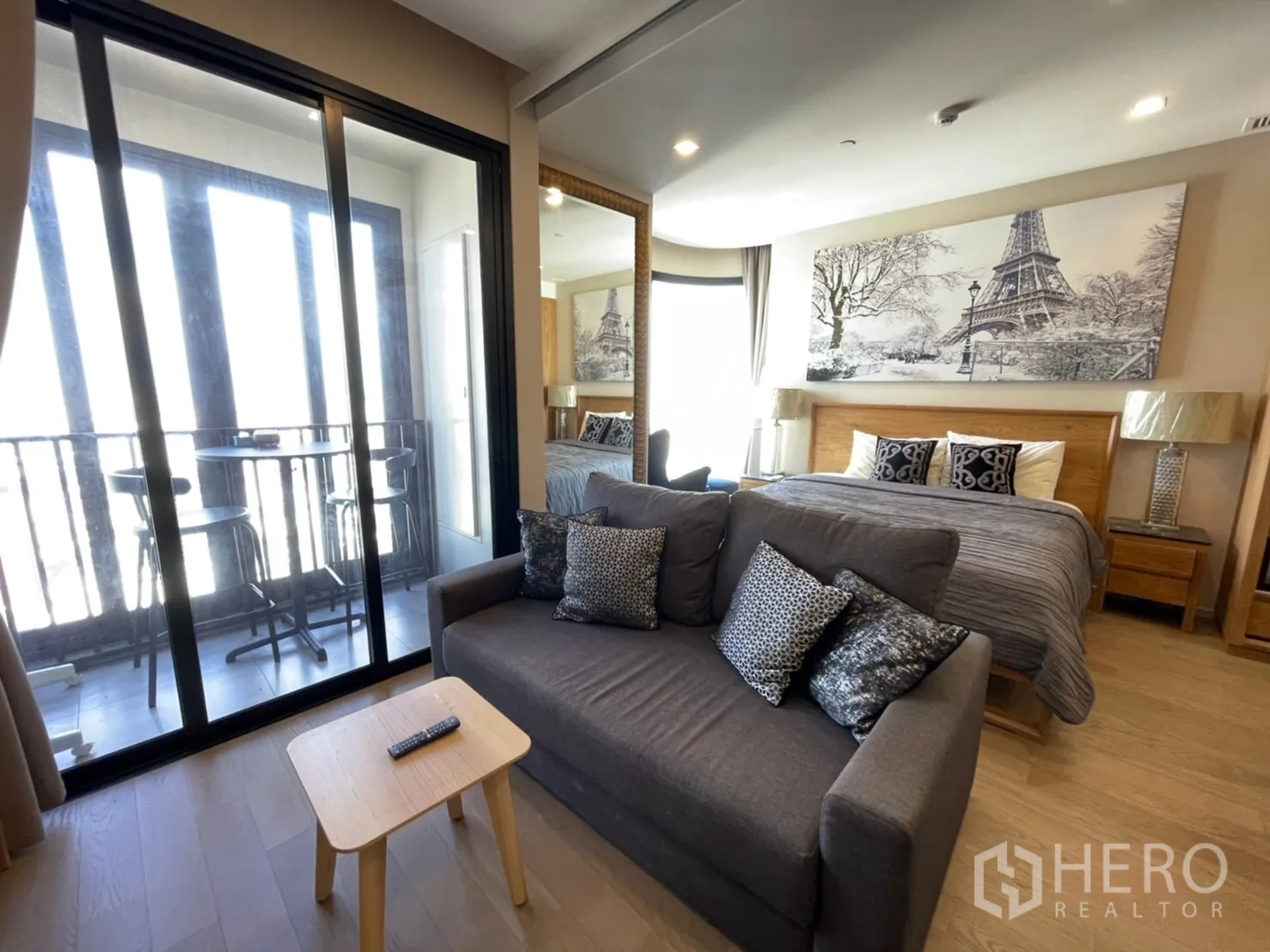คอนโด for rent in Watthana, Bangkok - พื้นที่นั่งเล่นและห้องนอนแบบโอเพ่นแปลน มีโซฟา เตียง และประตูกระจกเปิดสู่ระเบียง