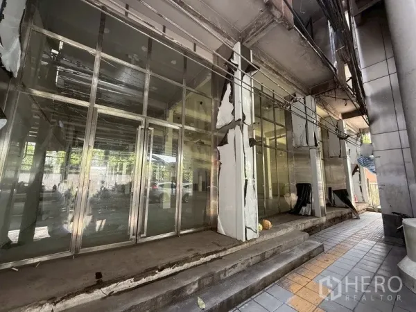 Shophouse for rent - Glass-fronted shophouse facade with metal frames and steps in Bang Chak, Phra Khanong.