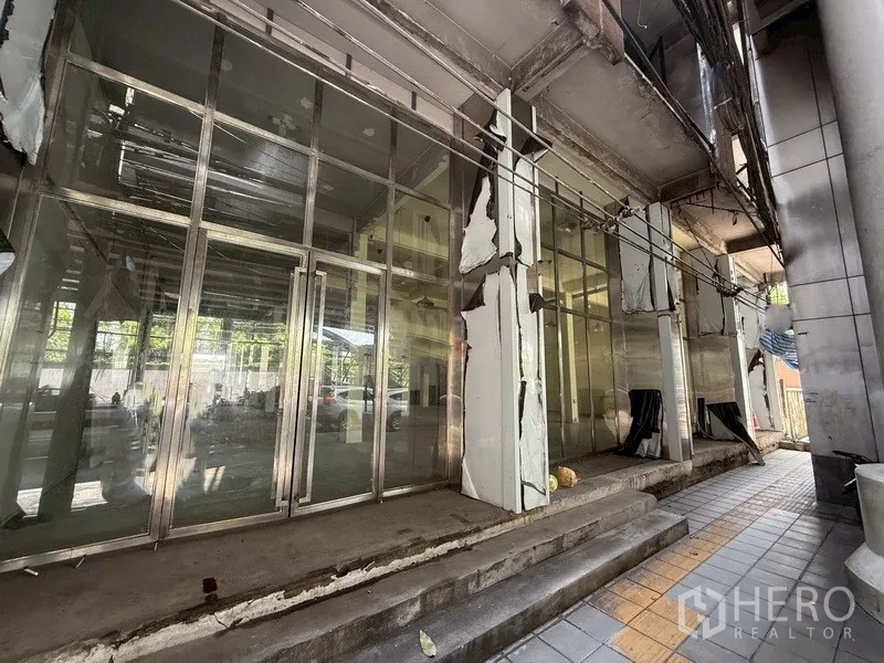 Shophouse for rent - Glass-fronted shophouse facade with metal frames and steps in Bang Chak, Phra Khanong.