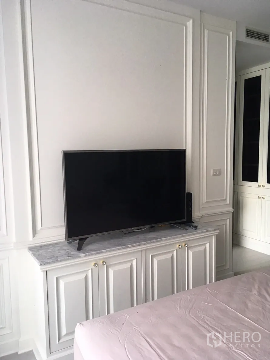 Condominium for rent in Pathum Wan, Bangkok - Bedroom media wall featuring a flat-screen TV on a marble-topped cabinet with built-in storage.
