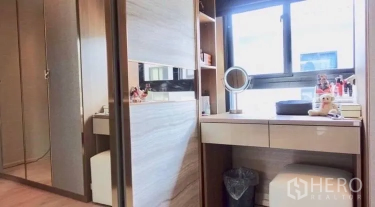 Townhouse for rent or sale in Suan Luang, Bangkok - Walk-in dressing area with mirrored wardrobes and a makeup vanity by the window.