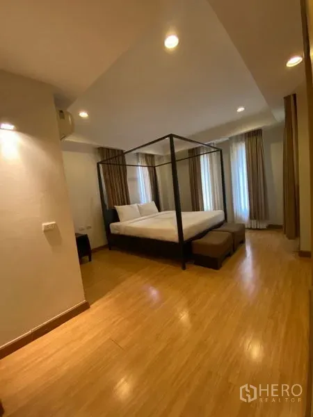 คอนโด ให้เช่าในWatthana, Bangkok - ห้องนอนหลัก เตียงสี่เสา ม้านั่งปลายเตียง พื้นไม้ และหน้าต่างมุมห้อง