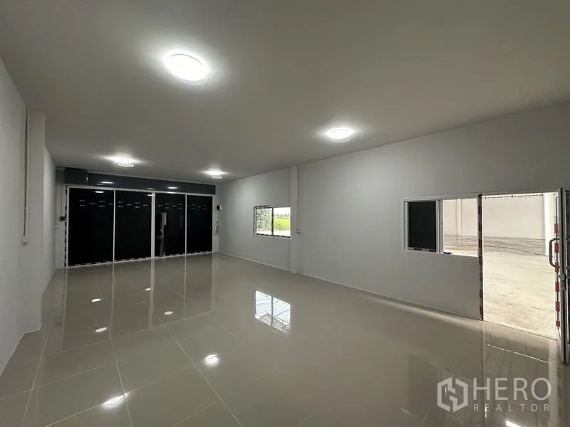 Warehouse for rent in Sai Noi, Nonthaburi - Air-conditioned style office room with glossy tile flooring and glass frontage.