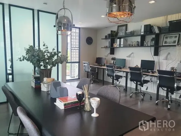 Home Office for rent in Bang Phli, Samut Prakan - Co-working style office floor with long workstations, a meeting-dining table, shelves and pendant lights.