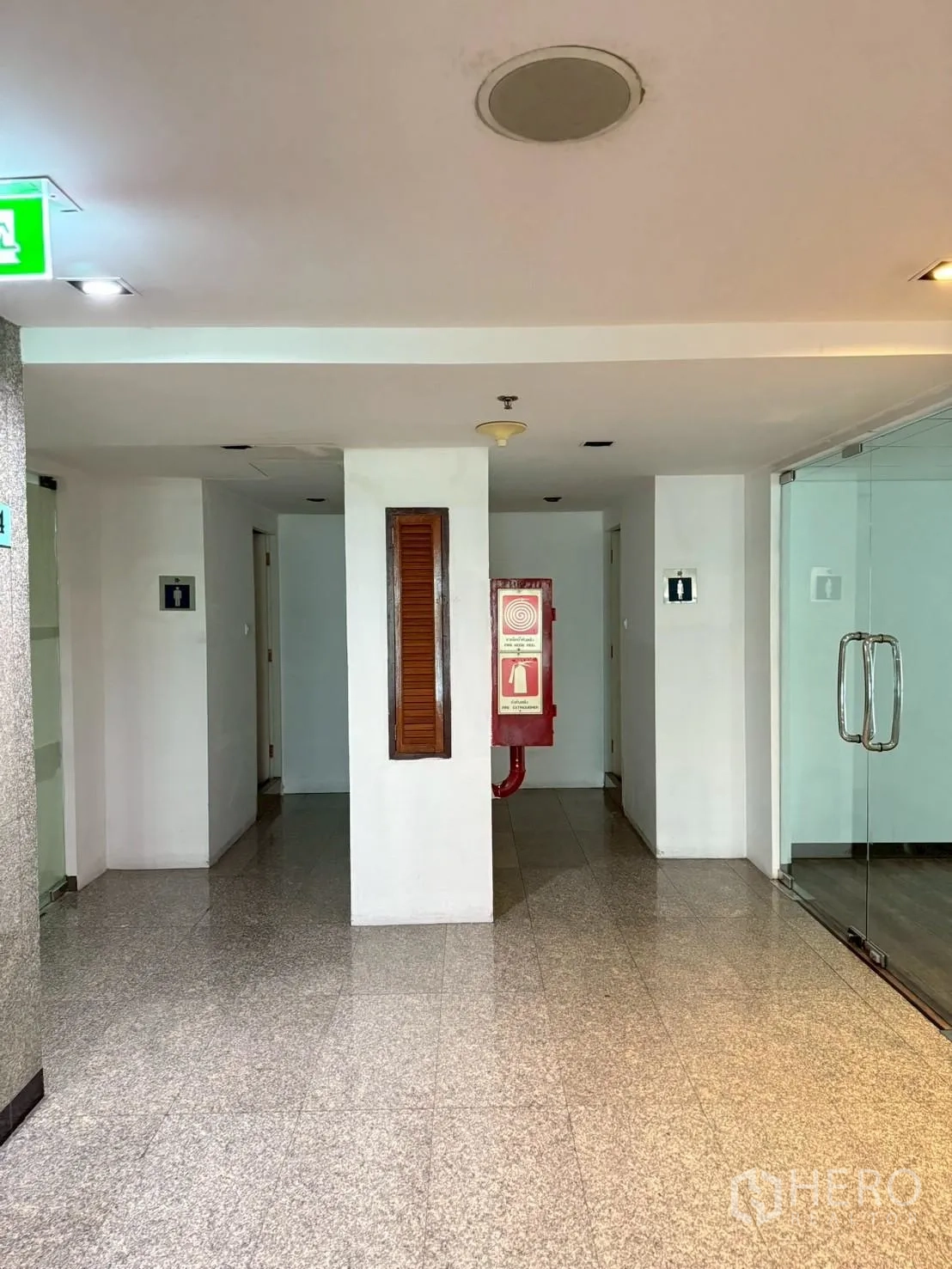Office Space for rent in Watthana, Bangkok - Building corridor with granite floors, fire hose cabinet, and glass office entry.