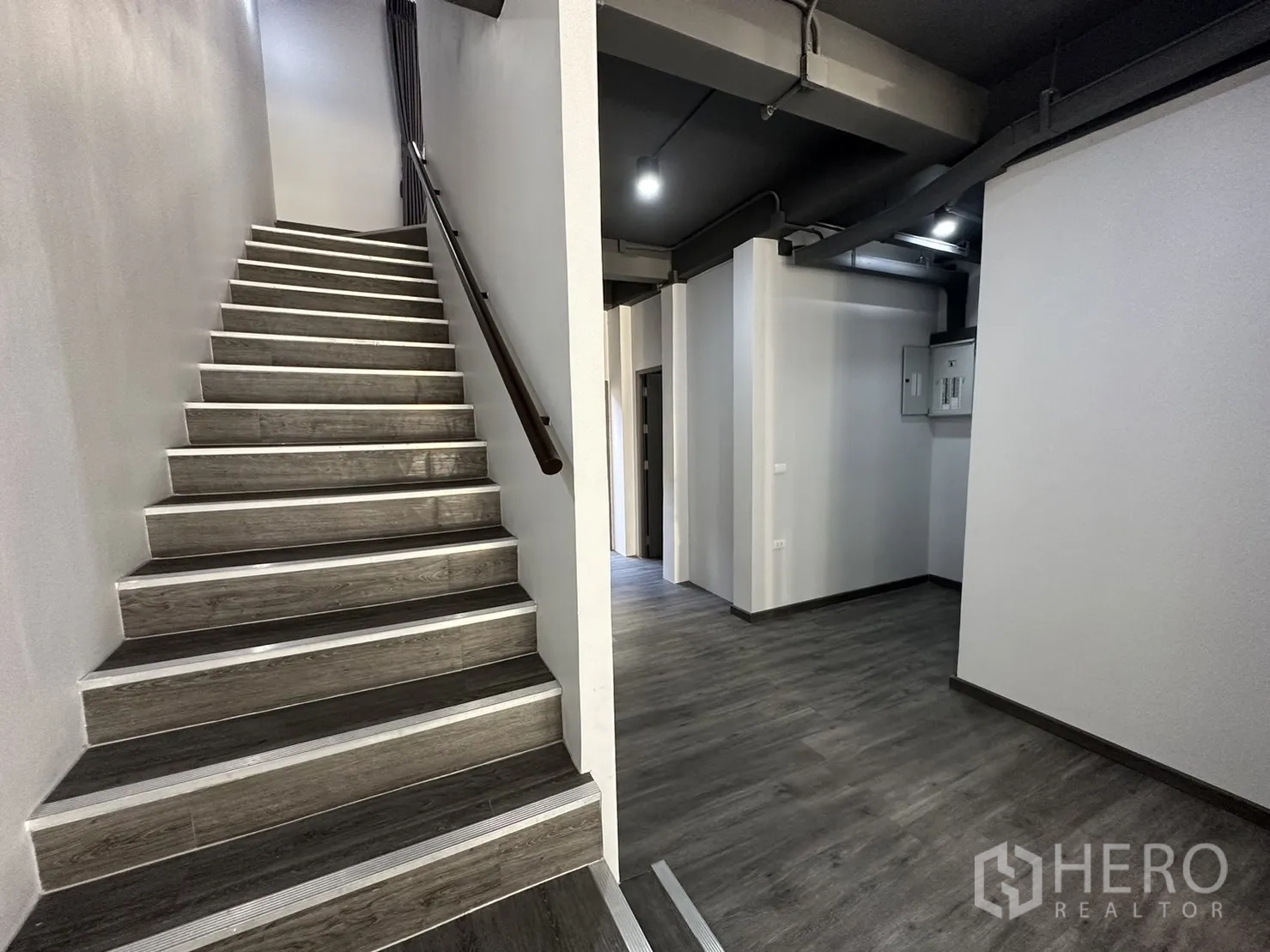 带办公室的家 出租或出售在Suan Luang, Bangkok - 宽阔楼梯与走廊，外露天花与深色木阶梯。