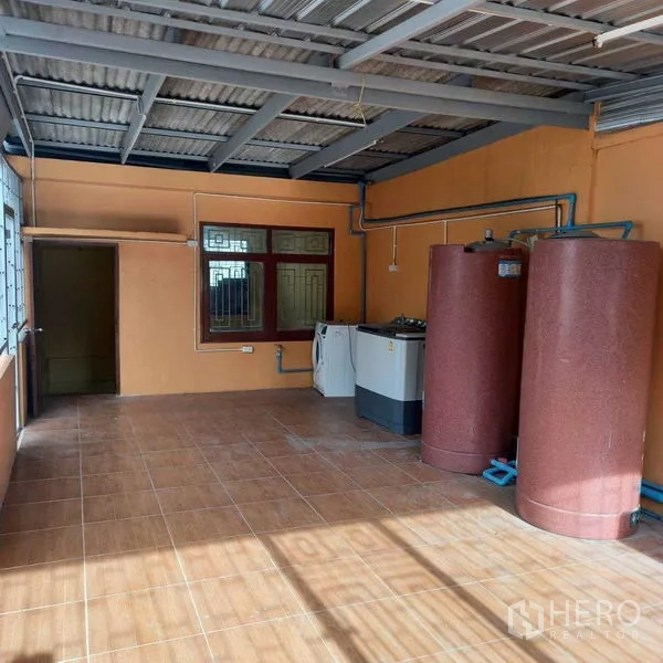 Shophouse for rent in Watthana, Bangkok - Covered rooftop terrace with water tanks, washing machine and tiled floor