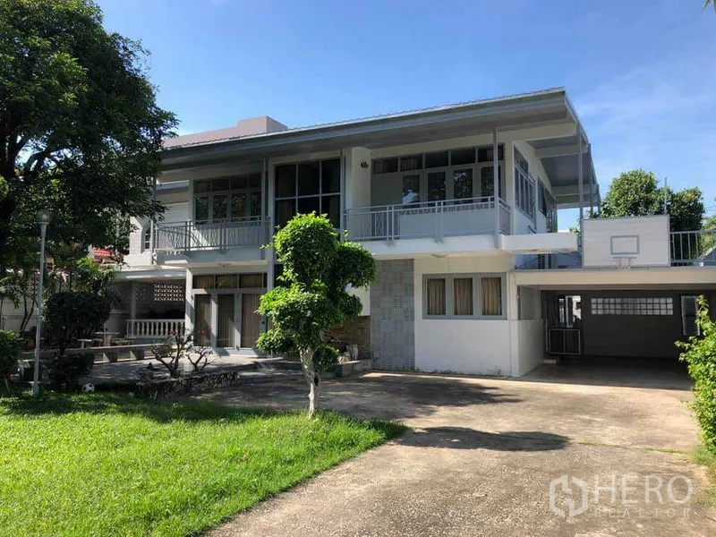 Detached House for rent in Phra Khanong, Bangkok - Two‑storey detached house exterior with wide driveway, balconies and covered carport.