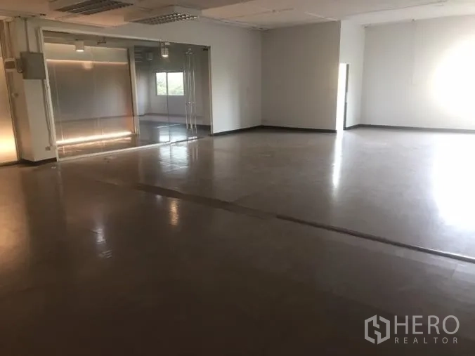 Office Space for rent in Watthana, Bangkok - Large open office floor with polished surface and a glass-partitioned meeting area.