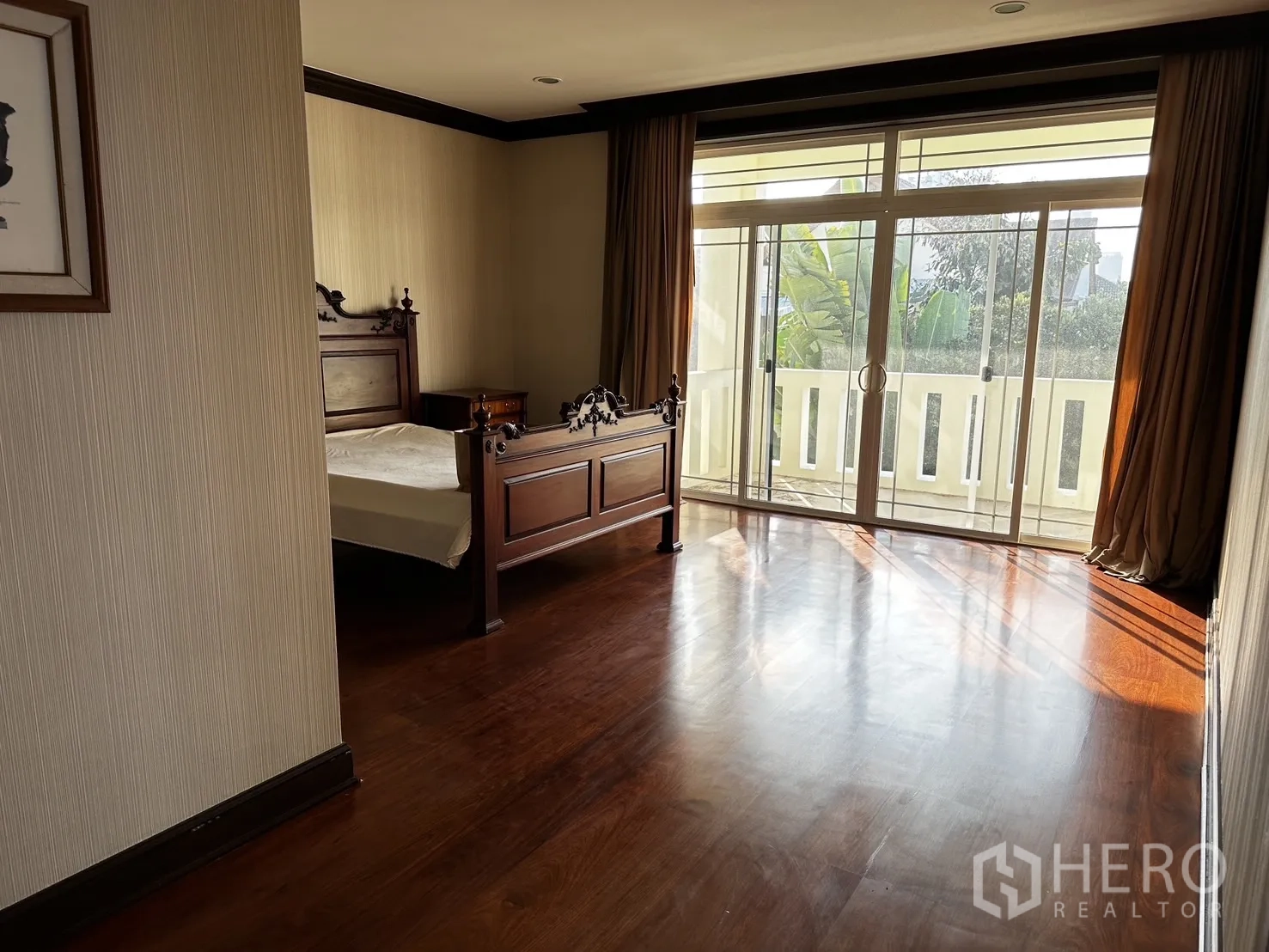Detached House for rent in Chatuchak, Bangkok - Bedroom opening to a balcony via sliding glass doors and wood flooring.