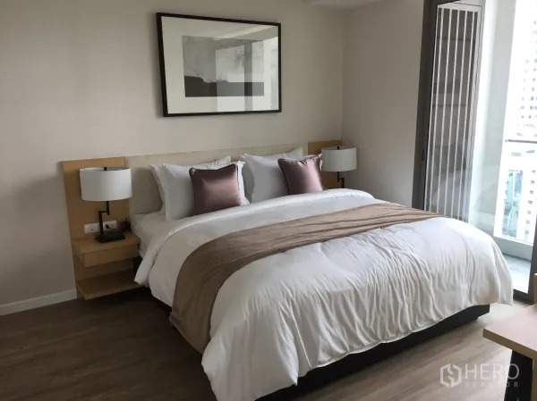 公寓 出售在Bang Rak, Bangkok - 主卧配大床与床头灯，浅色系装饰并可通往阳台