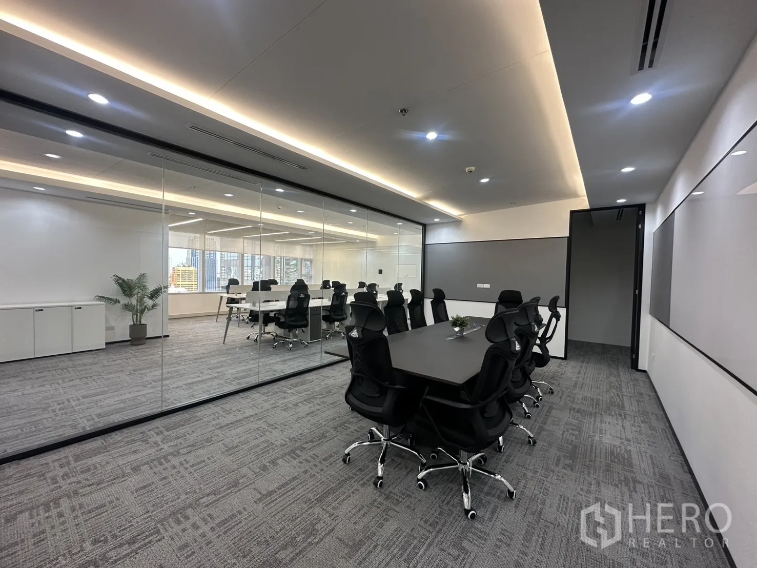 办公室 for rent in Pathum Wan, Bangkok - 主会议室配长桌与黑色座椅，置于通高玻璃墙后。