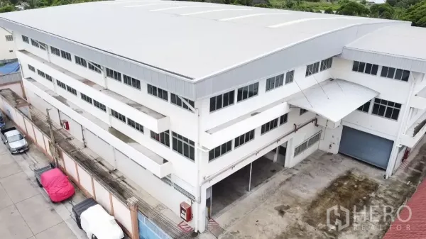 Factory for rent in Khlong Toei, Bangkok - Aerial view of a multi-storey factory with metal roof and loading yard.
