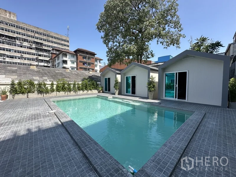带办公室的家 出租在Suan Luang, Bangkok - 私家泳池，三间池畔小屋与灰色泳池平台。