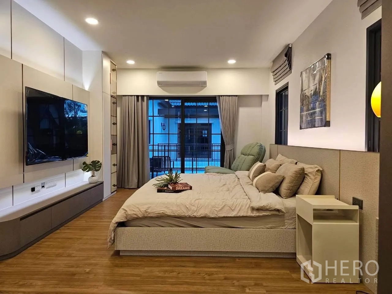 Detached House for rent or sale in Bang Phli, Samut Prakan - Bedroom with wall-mounted TV, curtains, and sliding glass doors.
