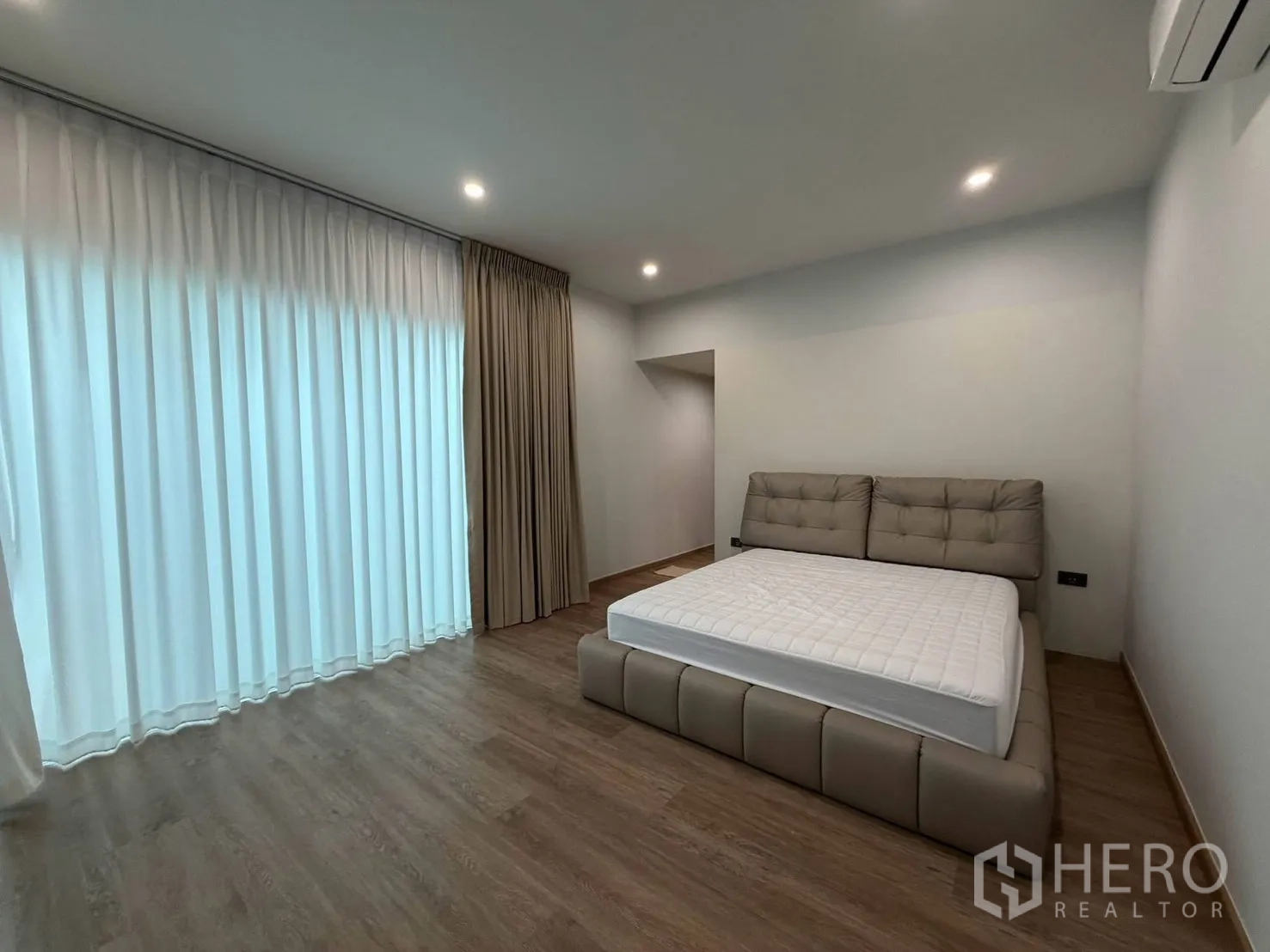 บ้านเดี่ยว for rent in Suan Luang, Bangkok - ห้องนอนกว้างพร้อมหน้าต่างบานใหญ่ ผ้าม่าน และพื้นลามิเนตไม้