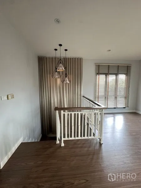 Detached House for rent or sale in Lam Luk Ka, Pathum Thani - Stair landing with geometric pendant lights, vertical feature wall and blinds.