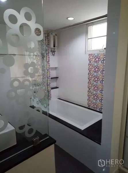 Condominium for rent in Watthana, Bangkok - Modern bathroom with bathtub, frosted glass partition, and window for ventilation.