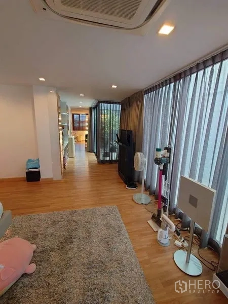 联排别墅 出售在Lat Phrao, Bangkok - 明亮起居/走廊区域，整面纱帘落地窗。