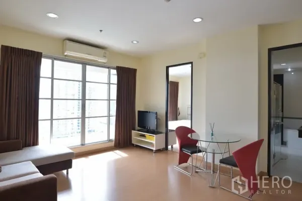 公寓 出租在Ratchathewi, Bangkok - 宽敞起居与用餐区，配空调与大窗，空间通透明亮。