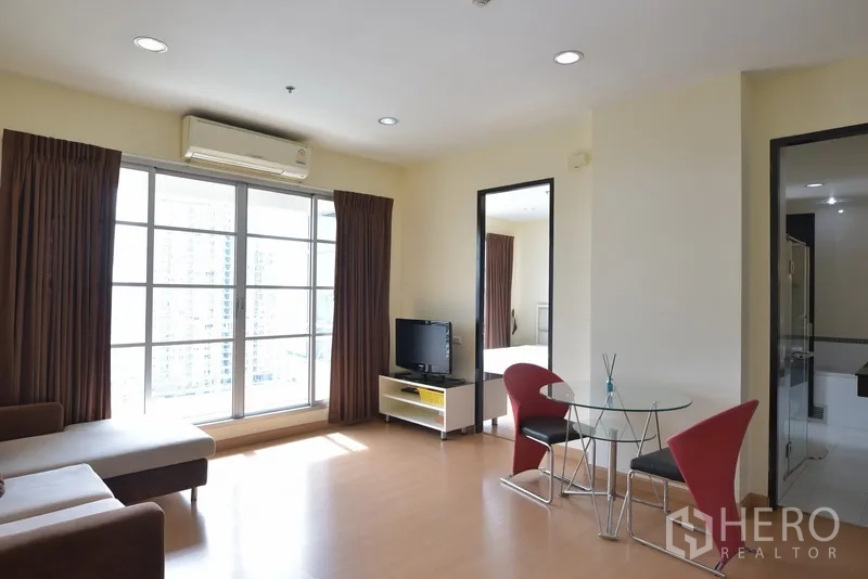 公寓 出租在Ratchathewi, Bangkok - 宽敞起居与用餐区，配空调与大窗，空间通透明亮。
