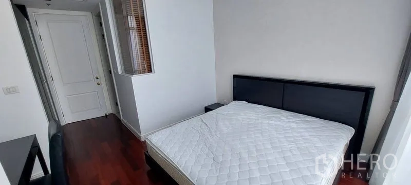 公寓 出租在Pathum Wan, Bangkok - 次卧带床与书桌，白墙木地板，窗户采光良好。