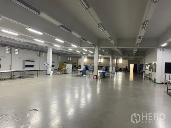 Warehouse for rent in Mueang Samut Prakan, Samut Prakan - Spacious warehouse production floor with high ceiling, bright strip lighting and columns in Samut Prakan.