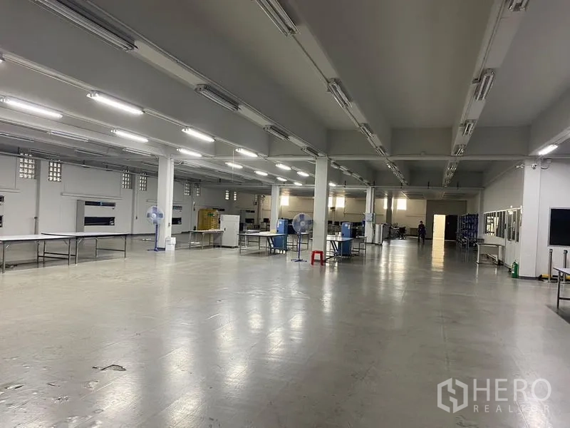 Warehouse for rent in Mueang Samut Prakan, Samut Prakan - Spacious warehouse production floor with high ceiling, bright strip lighting and columns in Samut Prakan.