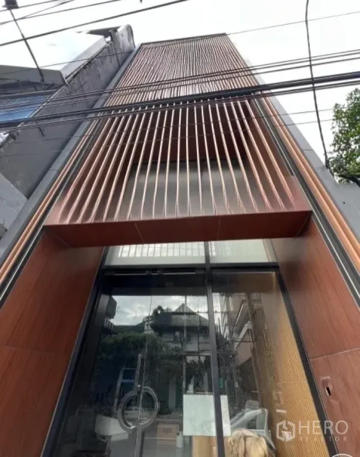 อาคารพาณิชย์ ให้เช่าในWatthana, Bangkok - ภาพระยะใกล้ของด้านหน้าอาคารพาณิชย์ กรุไม้ซี่แนวตั้งและประตูกระจกบานเลื่อน