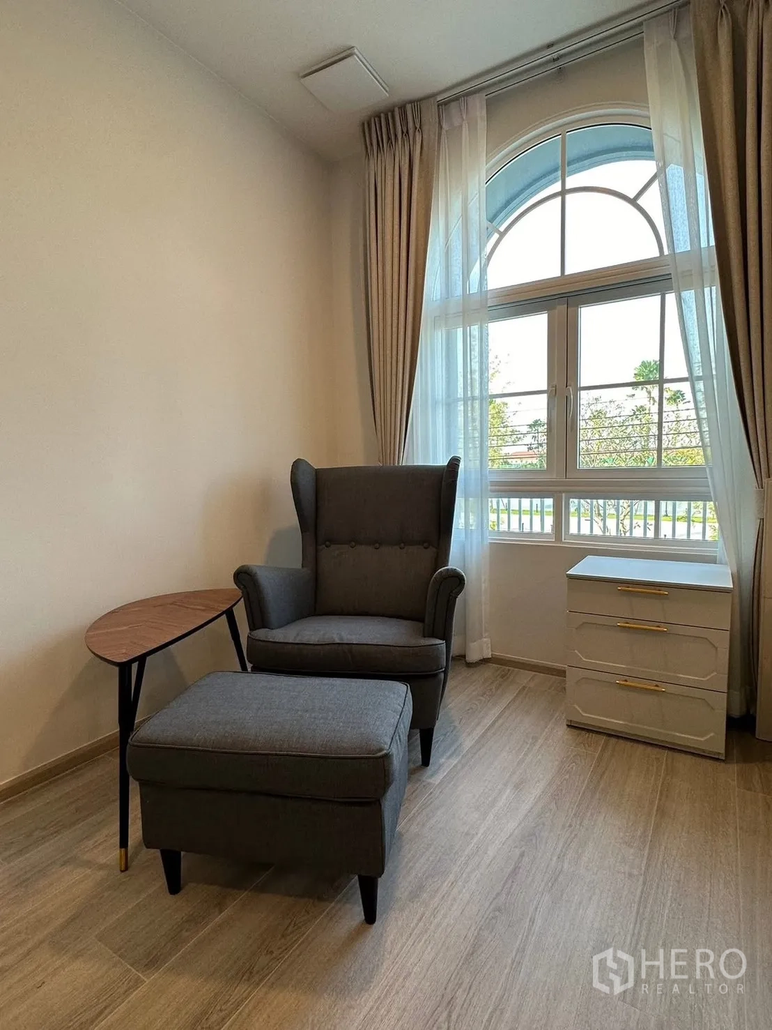 独栋房屋 for rent in Bang Phli, Samut Prakan - 阅读角，扶手椅与脚凳靠拱形窗。