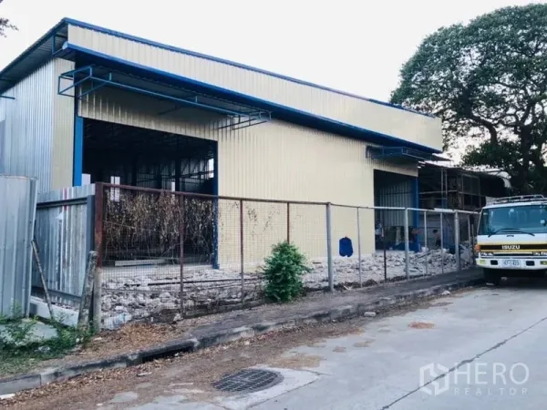 Warehouse for rent in Bang Kapi, Bangkok - Warehouse frontage with fence and large openings, suitable for loading and unloading.