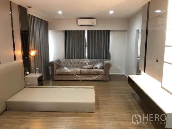 Detached House for rent in Prawet, Bangkok - Spacious bedroom lounge with sofa, bed base, wood flooring and air conditioning.