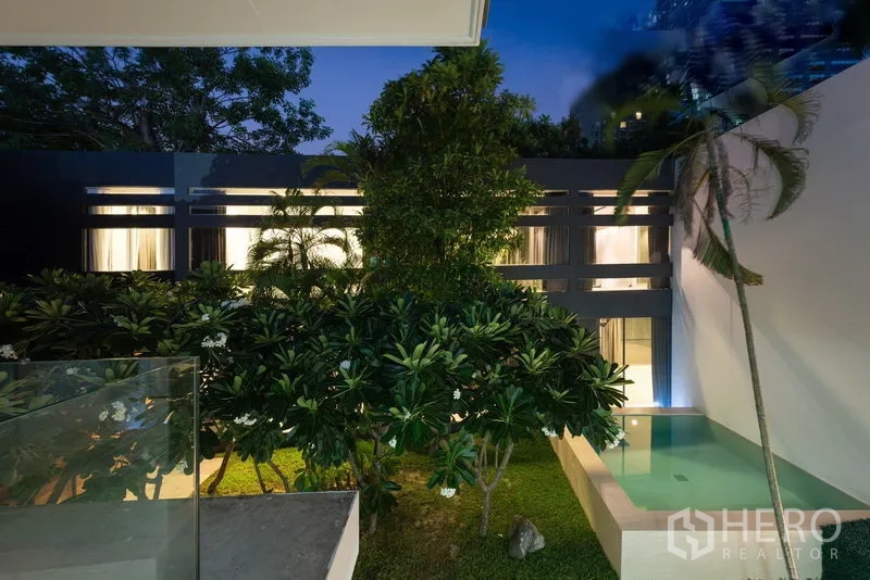 สำนักงานที่บ้าน ให้เช่าในKhlong Toei, Bangkok - มุมมองจากระเบียงยามค่ำ เห็นสวนเขียวชอุ่มและสระน้ำข้างอาคารทันสมัย