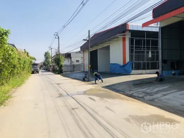 คลังสินค้า ให้เช่าในBang Kapi, Bangkok - แถวโกดังสมัยใหม่พร้อมประตูม้วนขนาดใหญ่และทางรถเข้าอยู่ริมถนนสองเลนในบางกะปิ กรุงเทพฯ