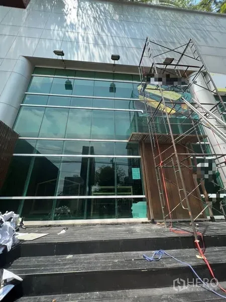 Retail Space for rent in Khlong Toei, Bangkok - Double-height glass storefront with steps and scaffolding at a modern retail building.
