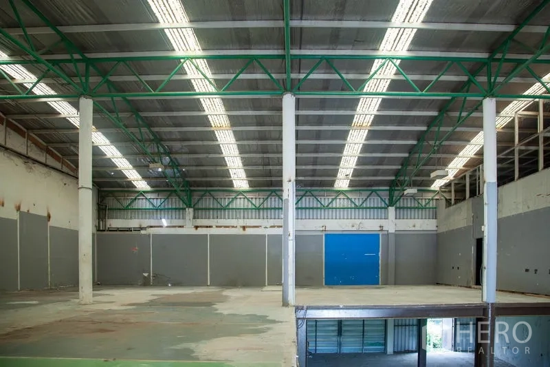 Warehouse for rent in Prawet, Bangkok - Raised platform under high-bay roof with skylights and structural columns in the warehouse.