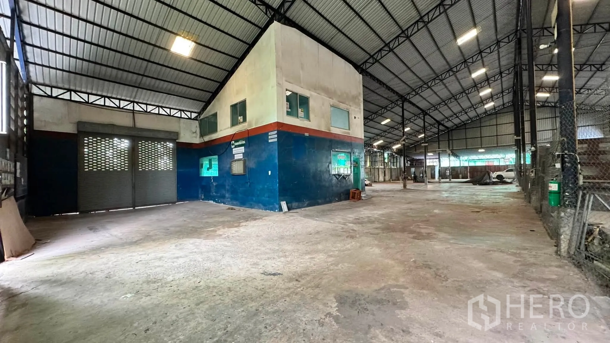 โกดัง for rent in Bang Khen, Bangkok - มุมโกดังที่มีออฟฟิศภายใน ประตูม้วน และพื้นคอนกรีต.