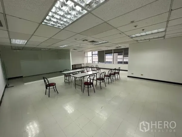 Office Space for rent in Chatuchak, Bangkok - Wide training-style office area with fluorescent lights and a row of windows.