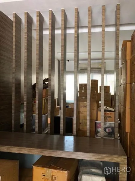 Townhouse for rent in Chatuchak, Bangkok - Ground-floor multipurpose area divided by a vertical slat partition with storage boxes.