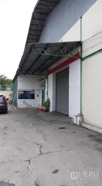 Warehouse for rent in Bang Phli, Samut Prakan - Side entrance with covered loading canopy and roller shutter door.