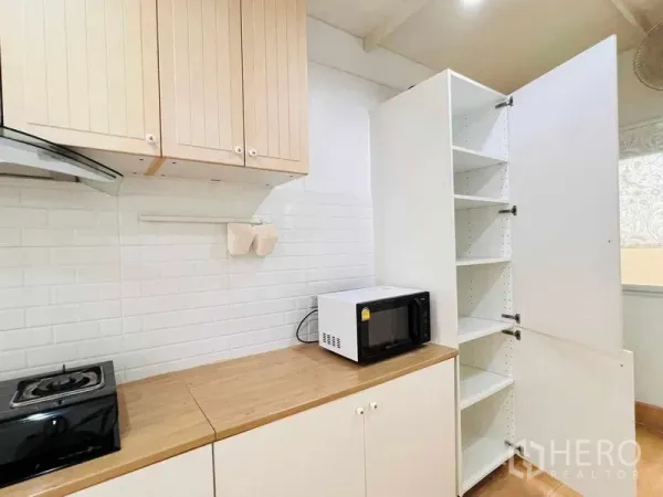 บ้าน ให้เช่าในLat Krabang, Bangkok - ชุดครัวบิวท์อินโทนขาว ผนังกระเบื้องลายอิฐ ไมโครเวฟและชั้นเก็บของสูง