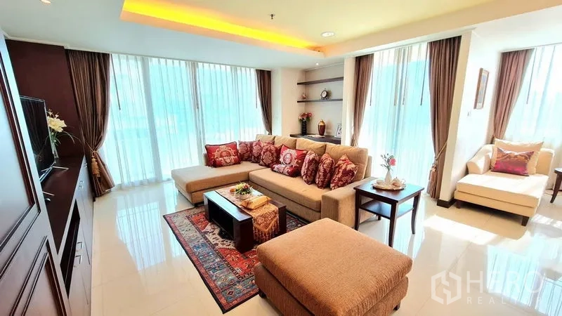 Apartment for rent in Watthana, Bangkok - Corner lounge with floor-to-ceiling windows, sectional sofa and TV built-ins.