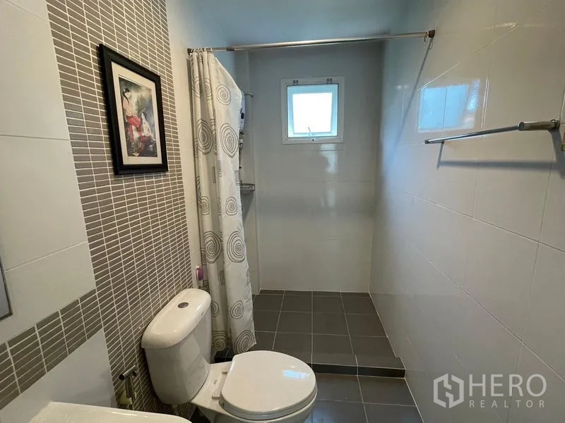 Detached House for sale in Lam Luk Ka, Pathum Thani - Bathroom with shower area, small window and neutral tiles.