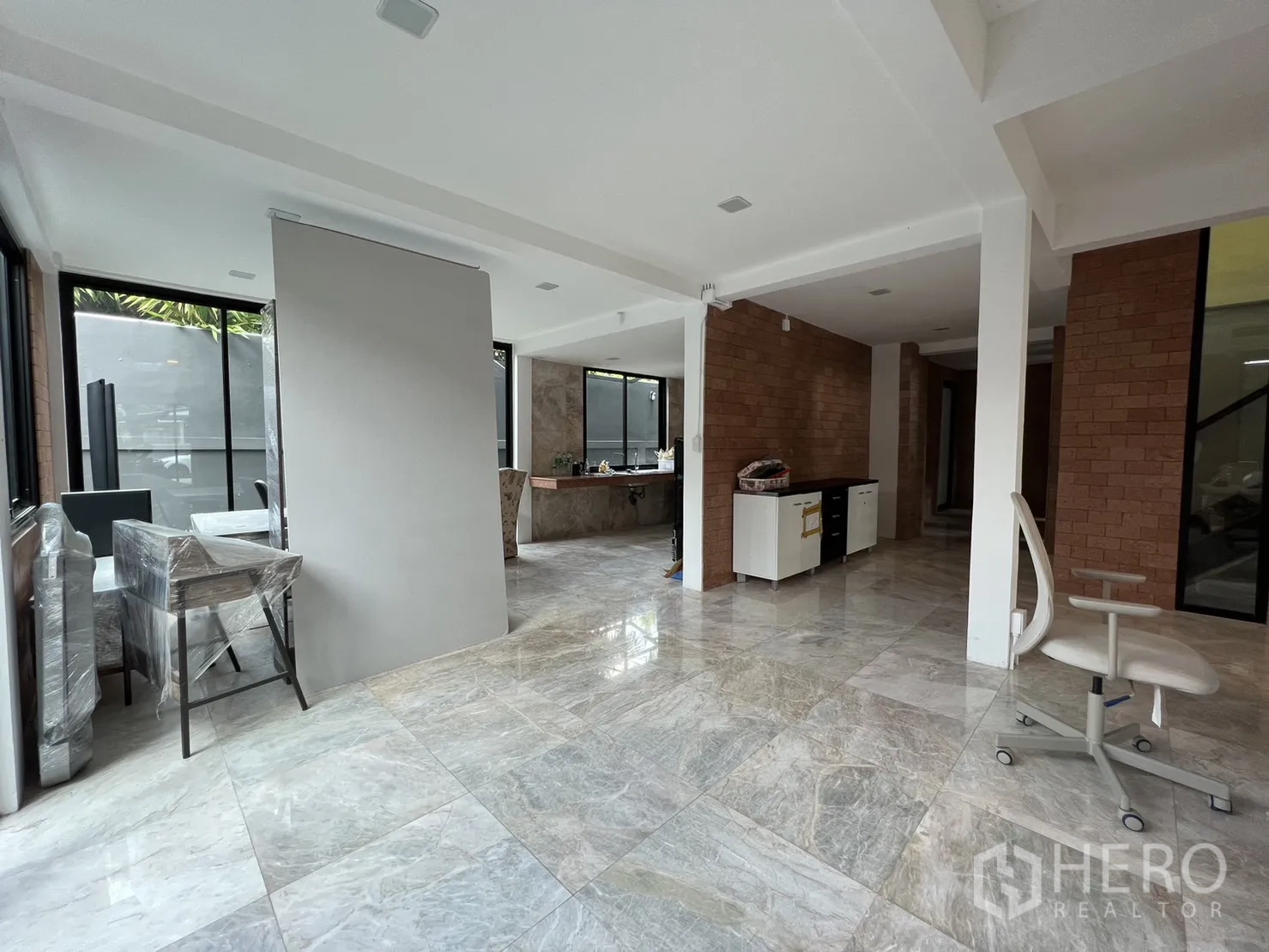 Detached House for rent or sale in Phra Khanong, Bangkok - Wide open-plan living and dining area with large windows and glossy stone tiles.
